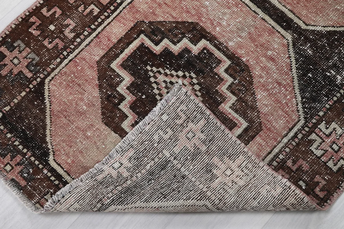 Corner of the rug folded back to reveal the hand-knotted cotton foundation