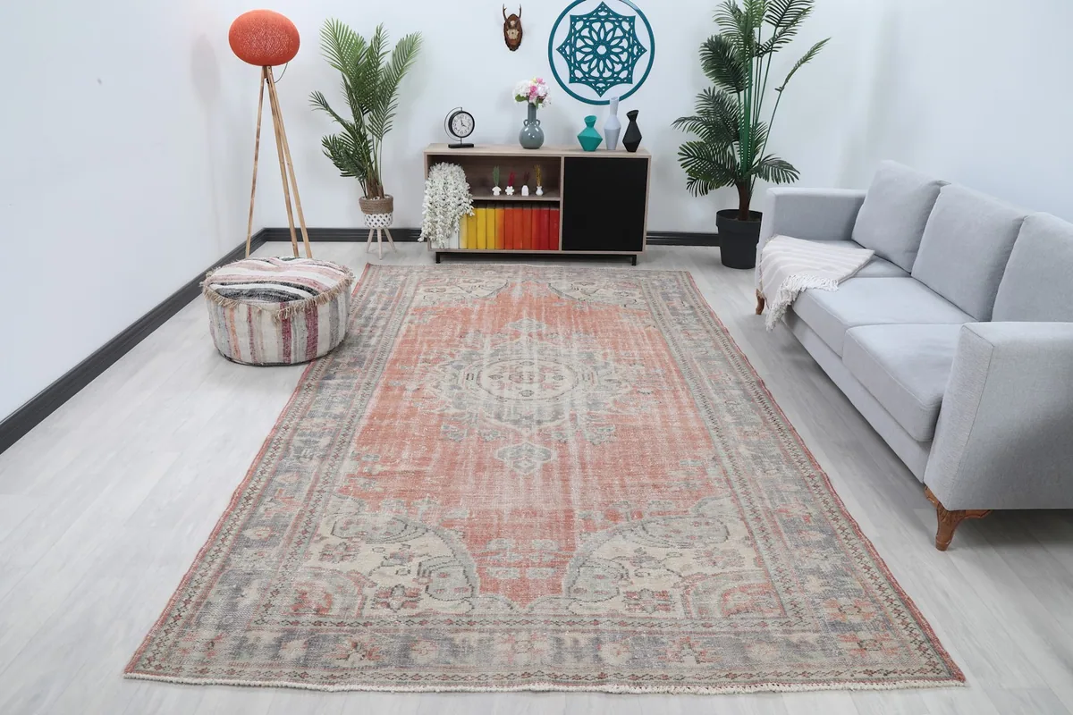 Vintage rust and gray area rug placed in a modern living room setting with a gray sofa