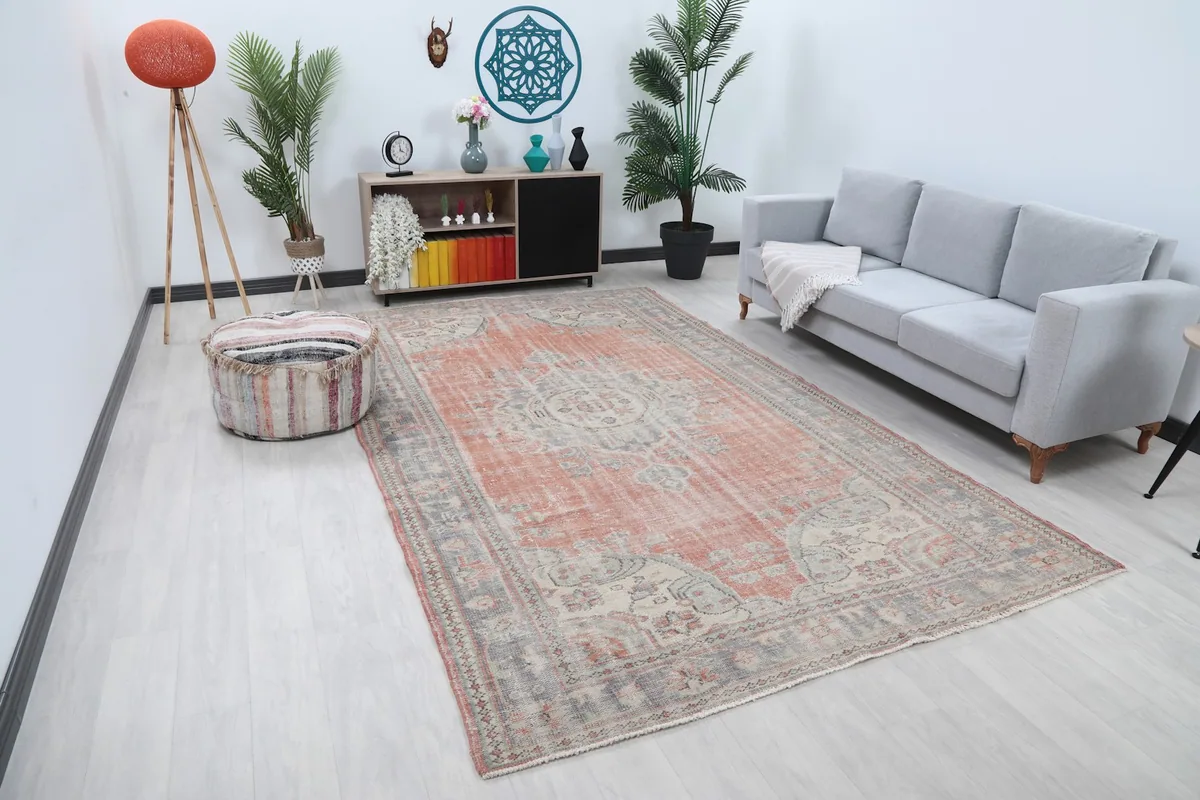 Wide view of the large vintage rug in a living space, showing its scale relative to furniture