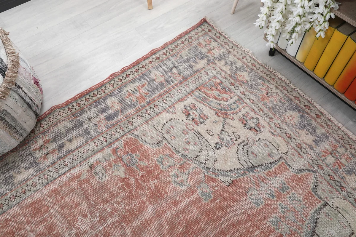 Corner detail of the rug, showing the border design and faded colors against the main field