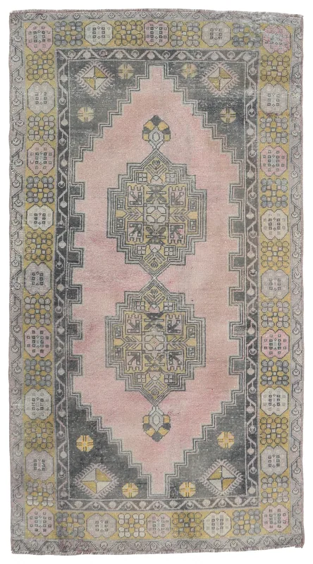 Full overhead view of the vintage pink, gray, and gold Anatolian area rug