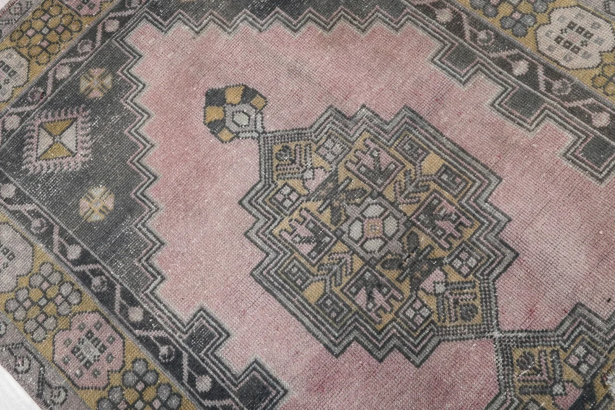 Detailed view of one of the geometric medallions on the pink field