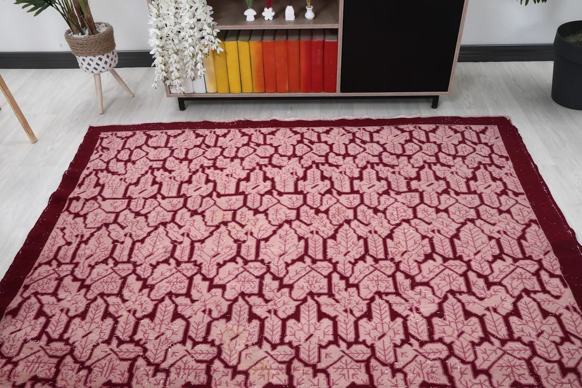 Overhead view of the rose and red vintage rug in a room with a console