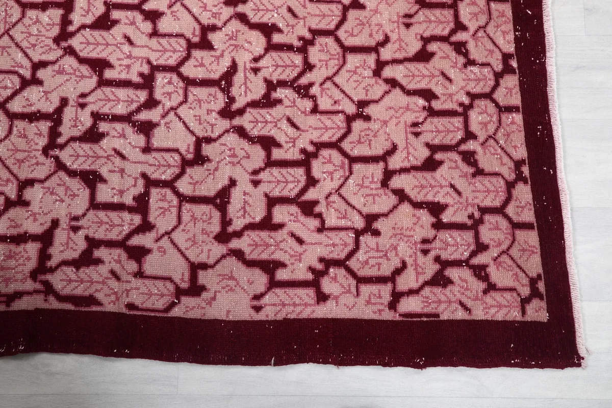 Close-up of the red border and rose geometric pattern on the vintage rug