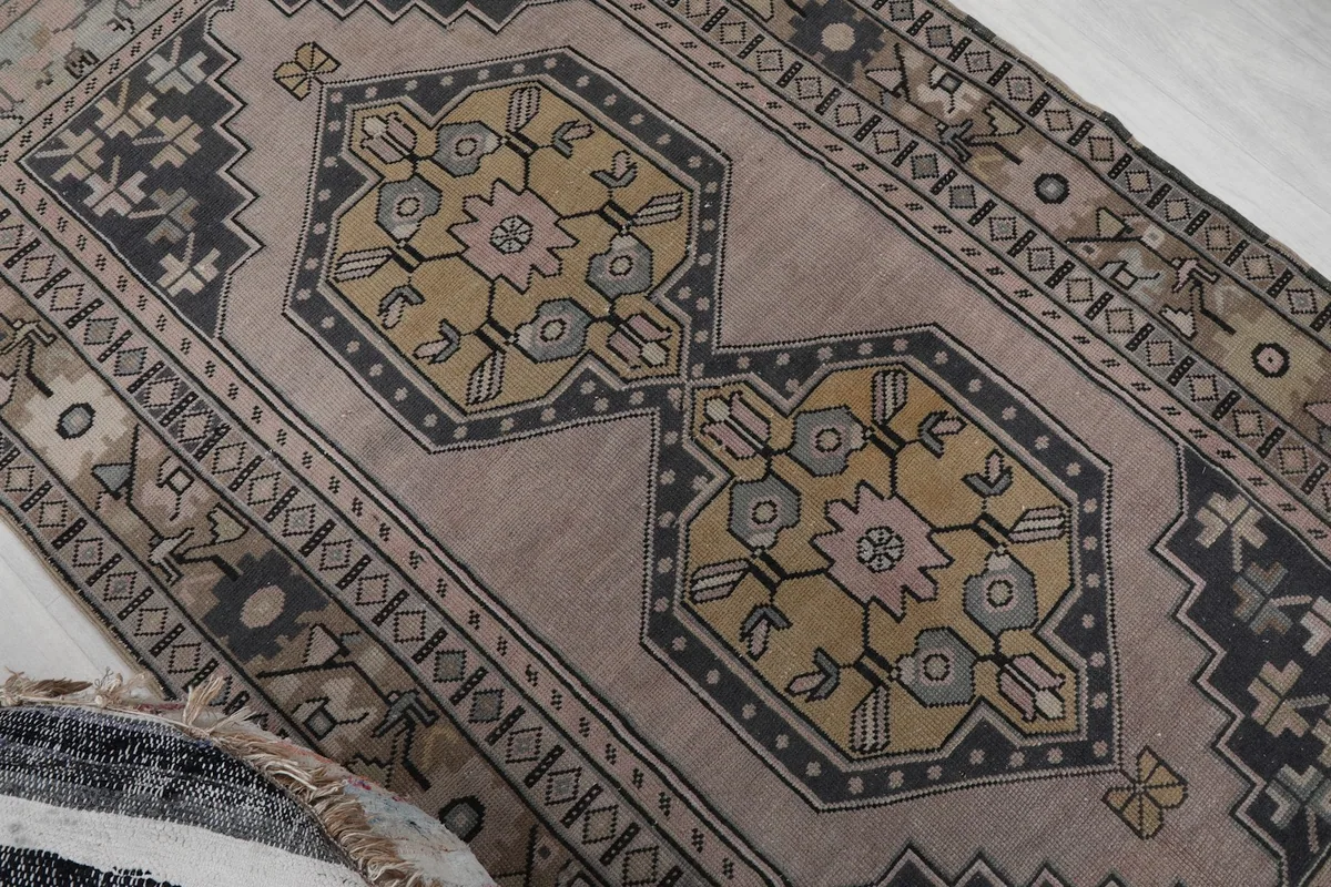 Close-up of the central medallion with yellow, charcoal, and pink geometric elements