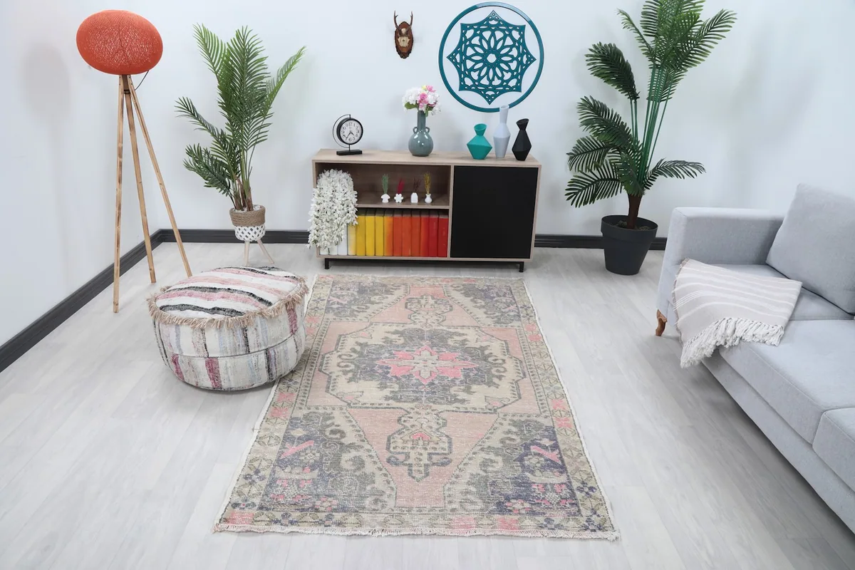 Vintage Anatolian rug displayed in a bright room with a gray sofa and wooden furniture
