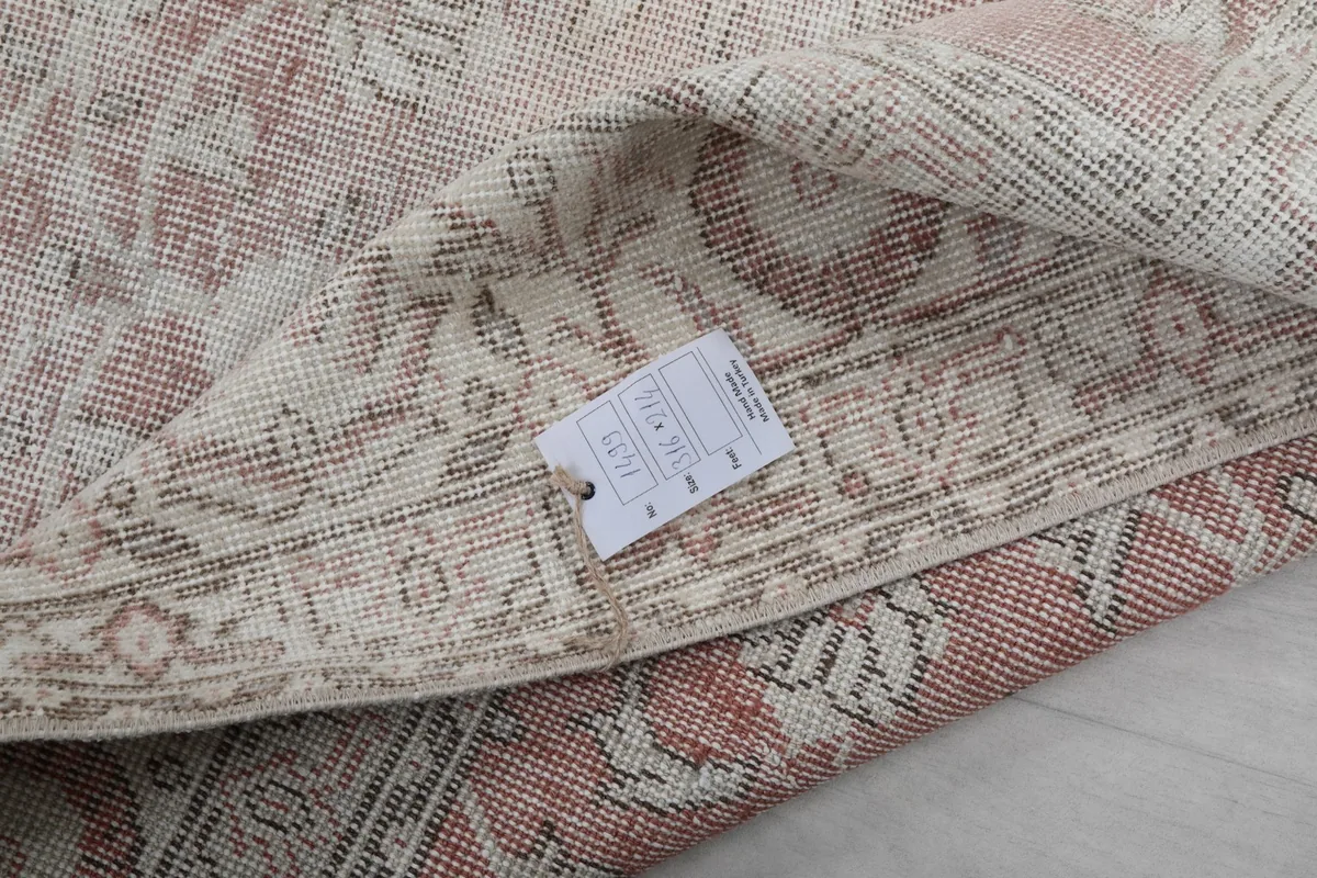 Close-up of the rug's back with a product tag, showing the wool pile and cotton foundation