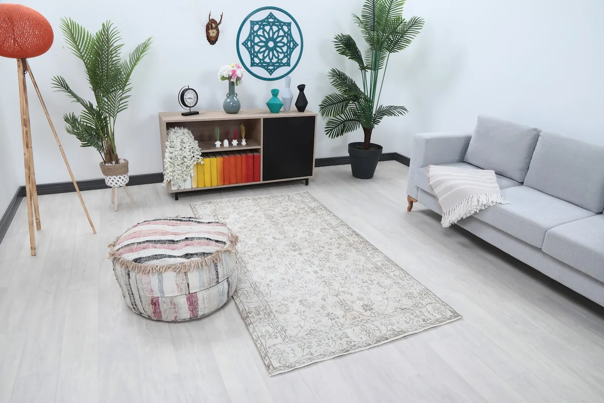 Angled view of the ivory floral vintage rug in a living room, showing its placement