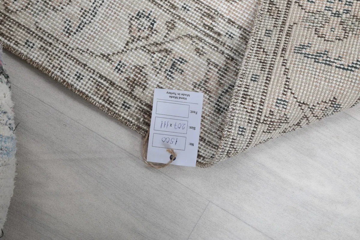 Rug tag displaying dimensions and origin, folded over the corner of the rug