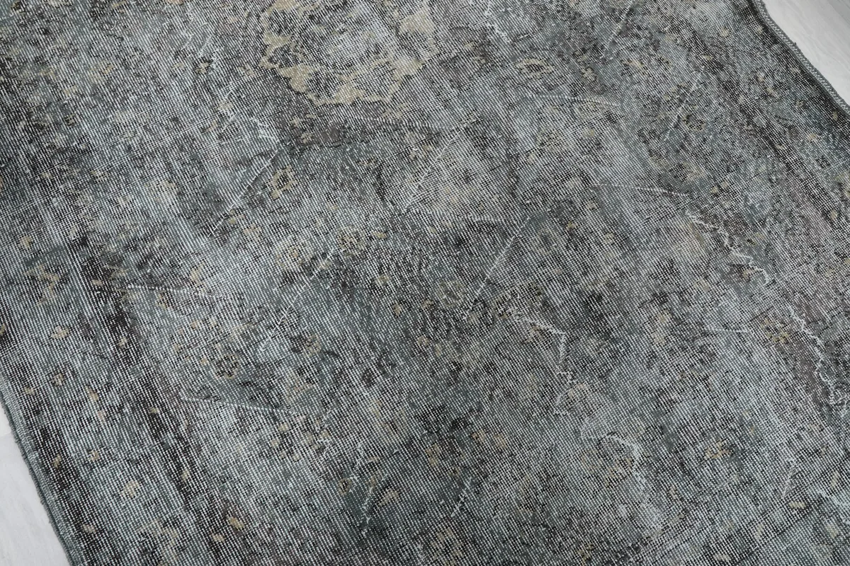 Textural detail of the hand-knotted wool pile with variations in gray and charcoal tones