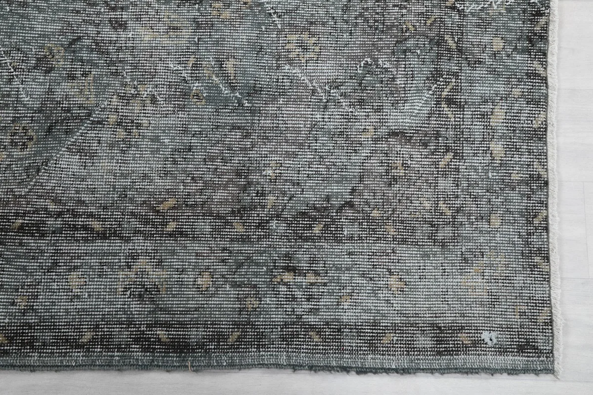 Detail of the rug's border and corner, showing the subtle design and texture