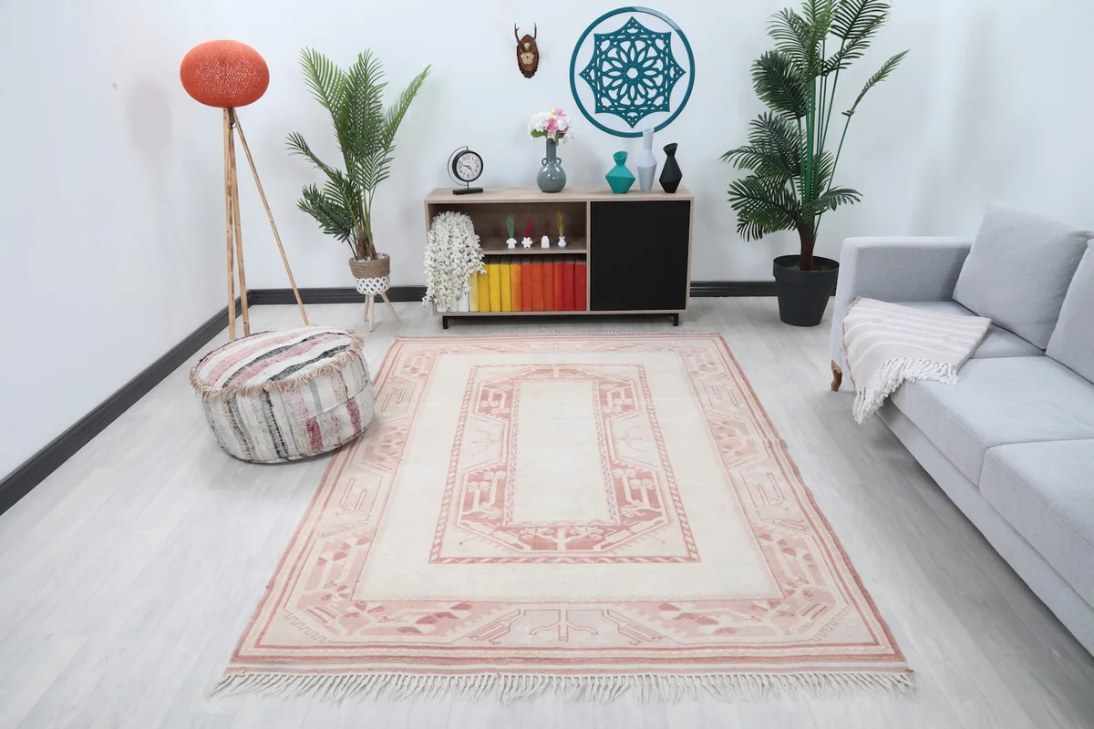 Ivory and rose vintage rug in a modern living room setting with a gray sofa