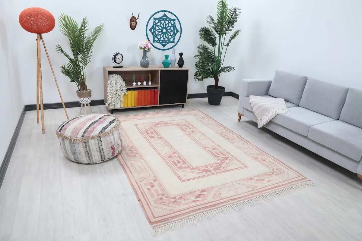 Wide view of the ivory and rose geometric rug complementing a neutral living space