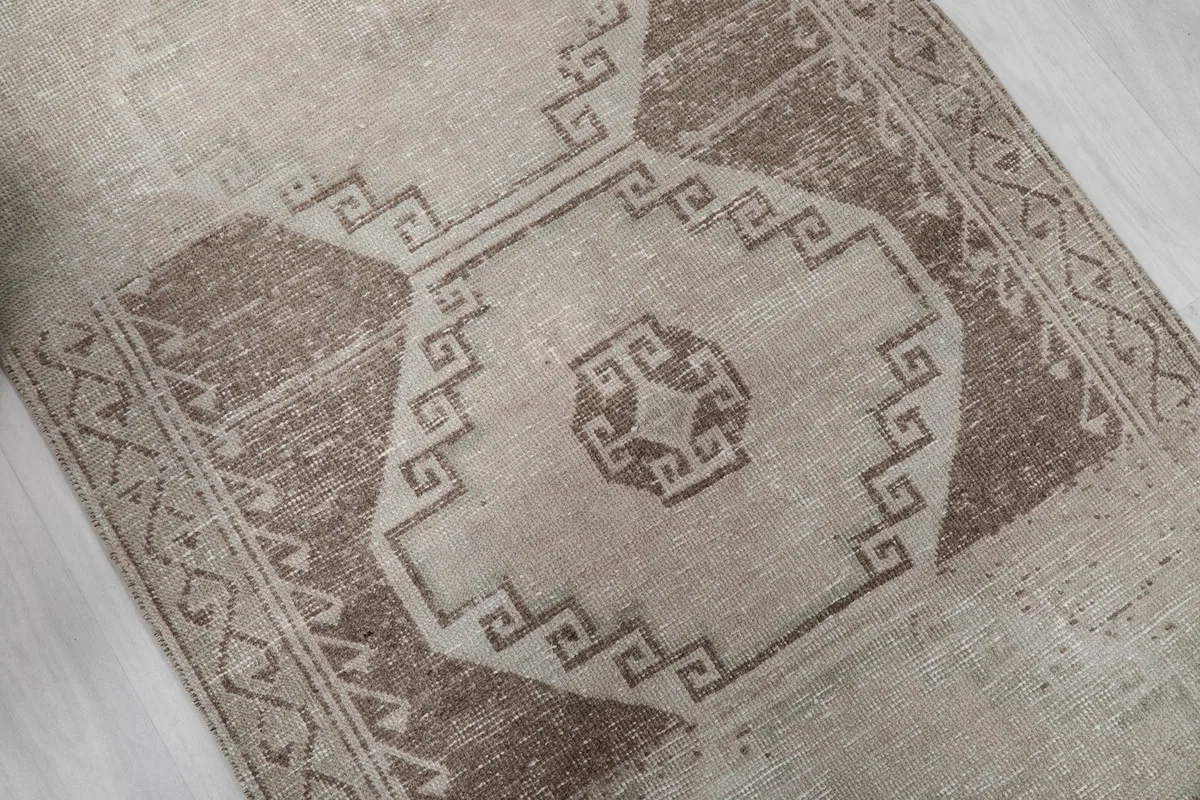 Close-up of the central brown medallion and surrounding geometric patterns on the rug