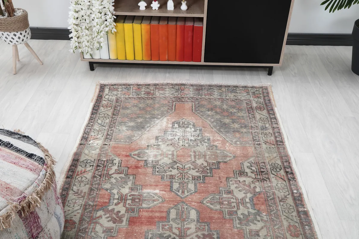 Overhead angle shot of the vintage rug, capturing its full design and colors in a room setting.