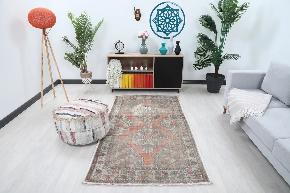 Vintage rust and gray Anatolian rug displayed in a modern living room setting.