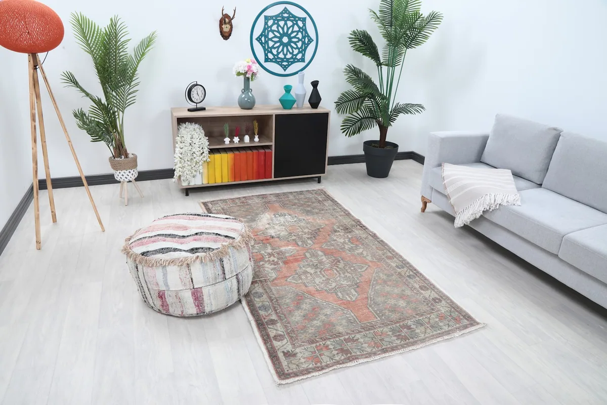 Angle view of the rust and gray vintage rug in a living room, showing its placement.