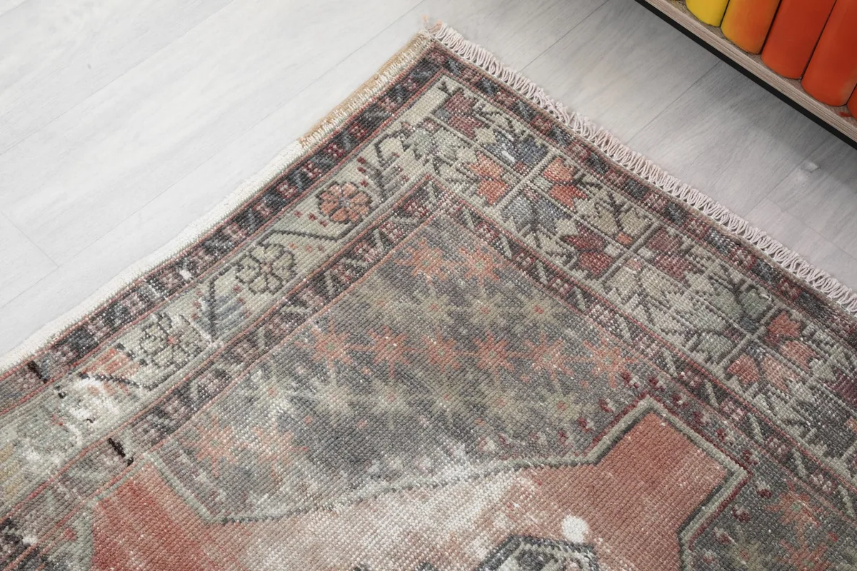 Close-up of the rug's top corner, showcasing the border design and color variations.