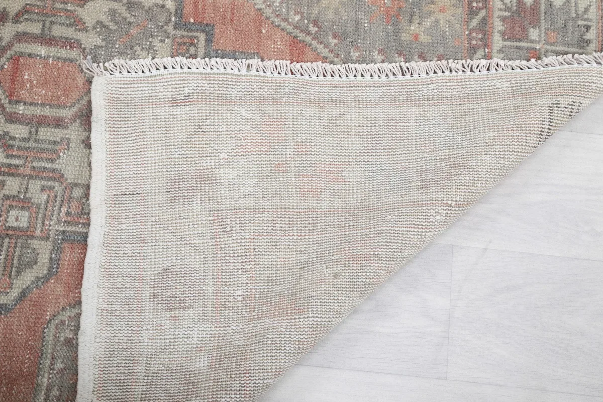 Close-up of the rug's back, showing the tight hand-knotted weave and foundation.