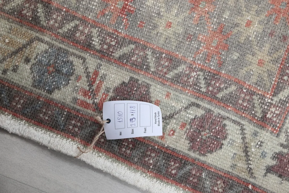 Close-up of the rug's fringe and a small portion of the border, with a product tag visible.