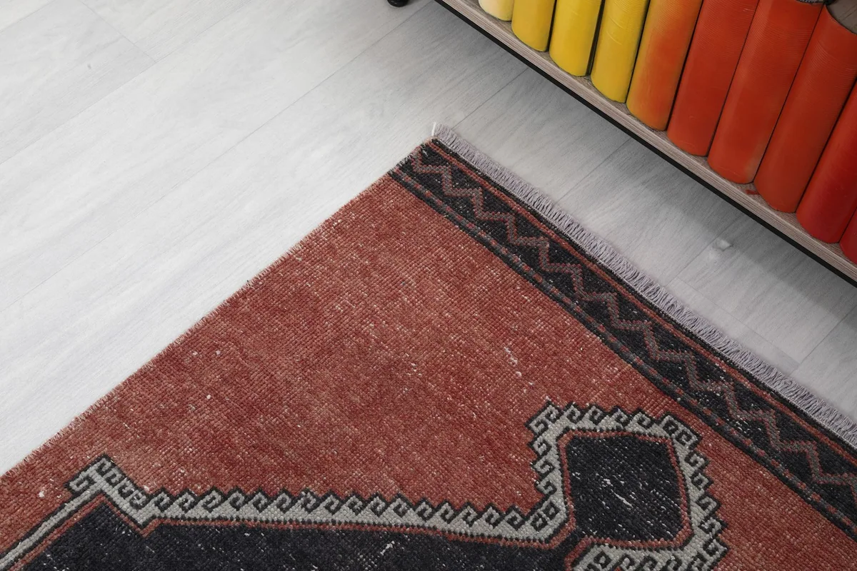 Close-up of the rug's border and corner, showing the edge finishing and a small section of the pattern.