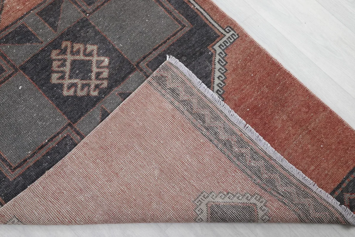 View of the back of the rug, folded to reveal the hand-knotted construction and cotton foundation.