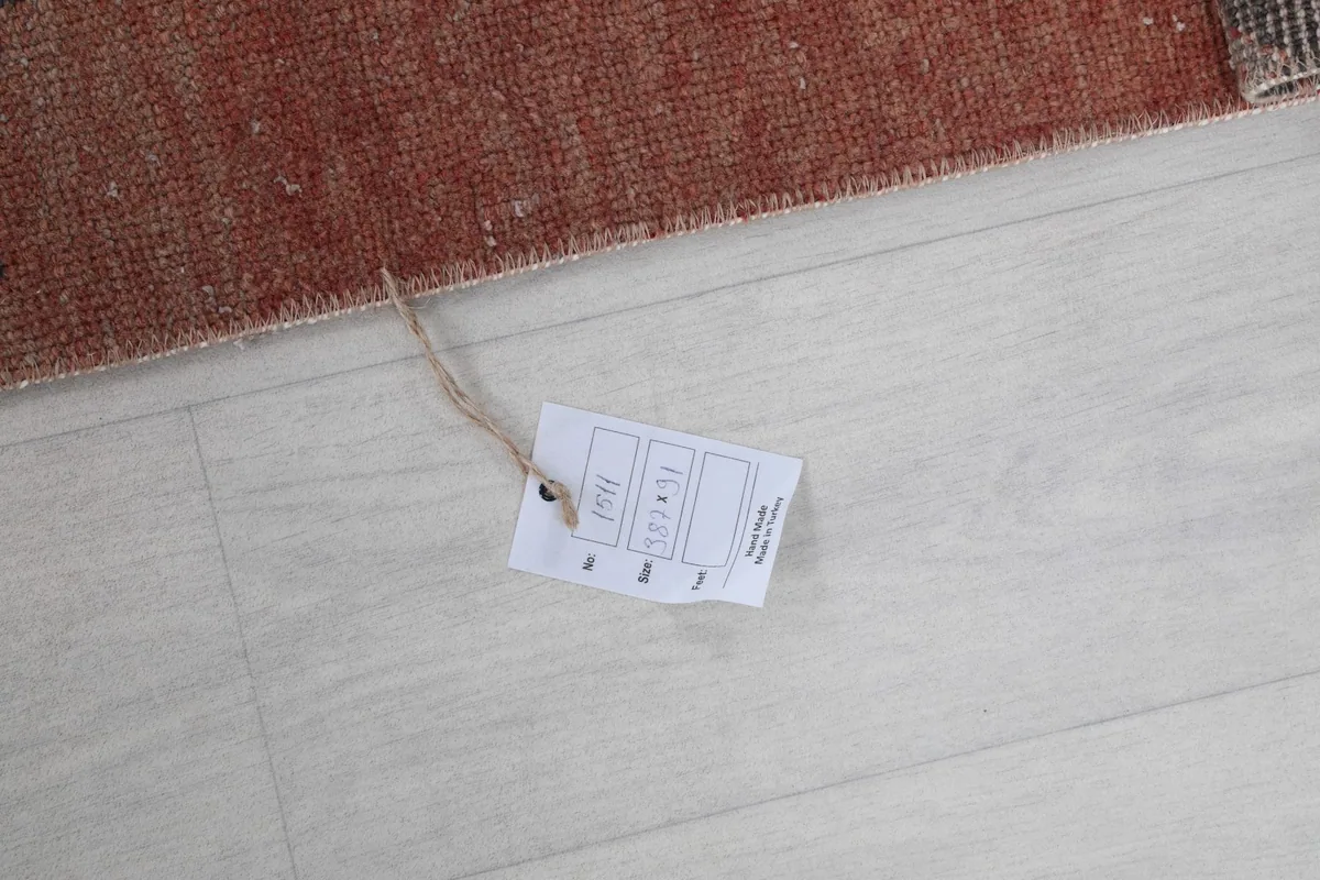 Product tag on the floor next to the rug, providing information about its origin and materials.