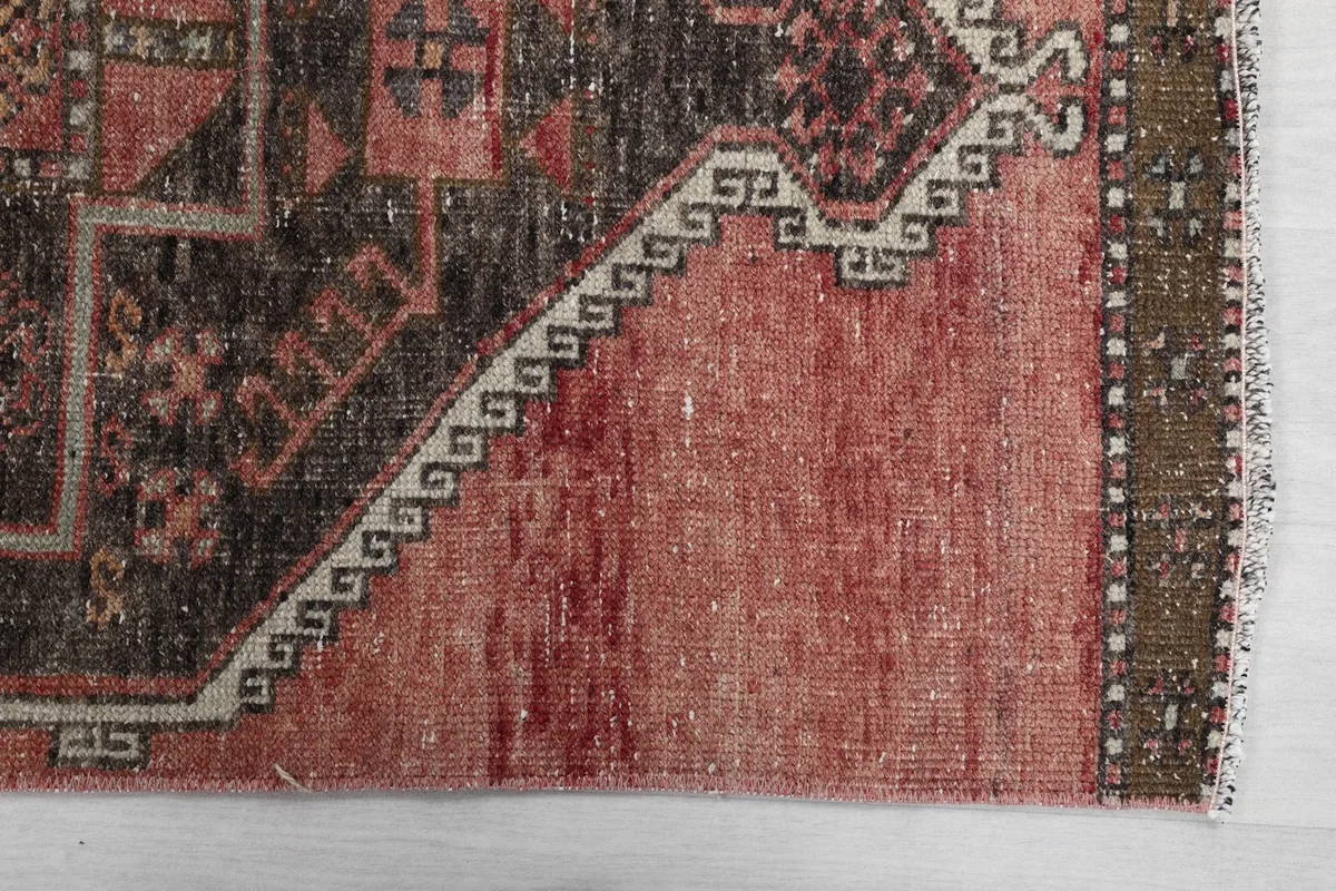 Detailed corner view of the rust field and charcoal border with white geometric accents.