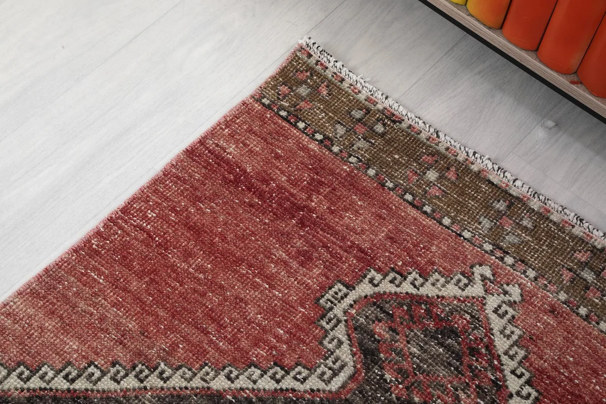 Close-up of the rug's edge, showing the subtle brown border and the geometric pattern transition.