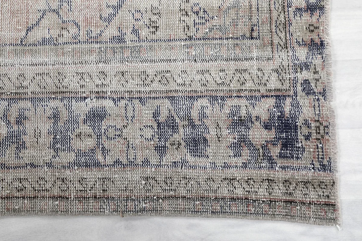 Detail of the gray and blue floral and geometric border design on the rug