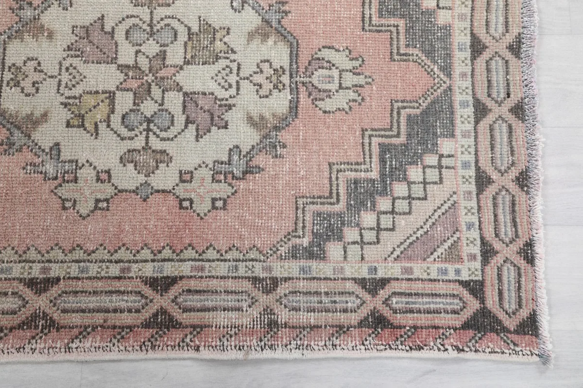 Detailed view of the corner motif and geometric border pattern in gray and brown tones