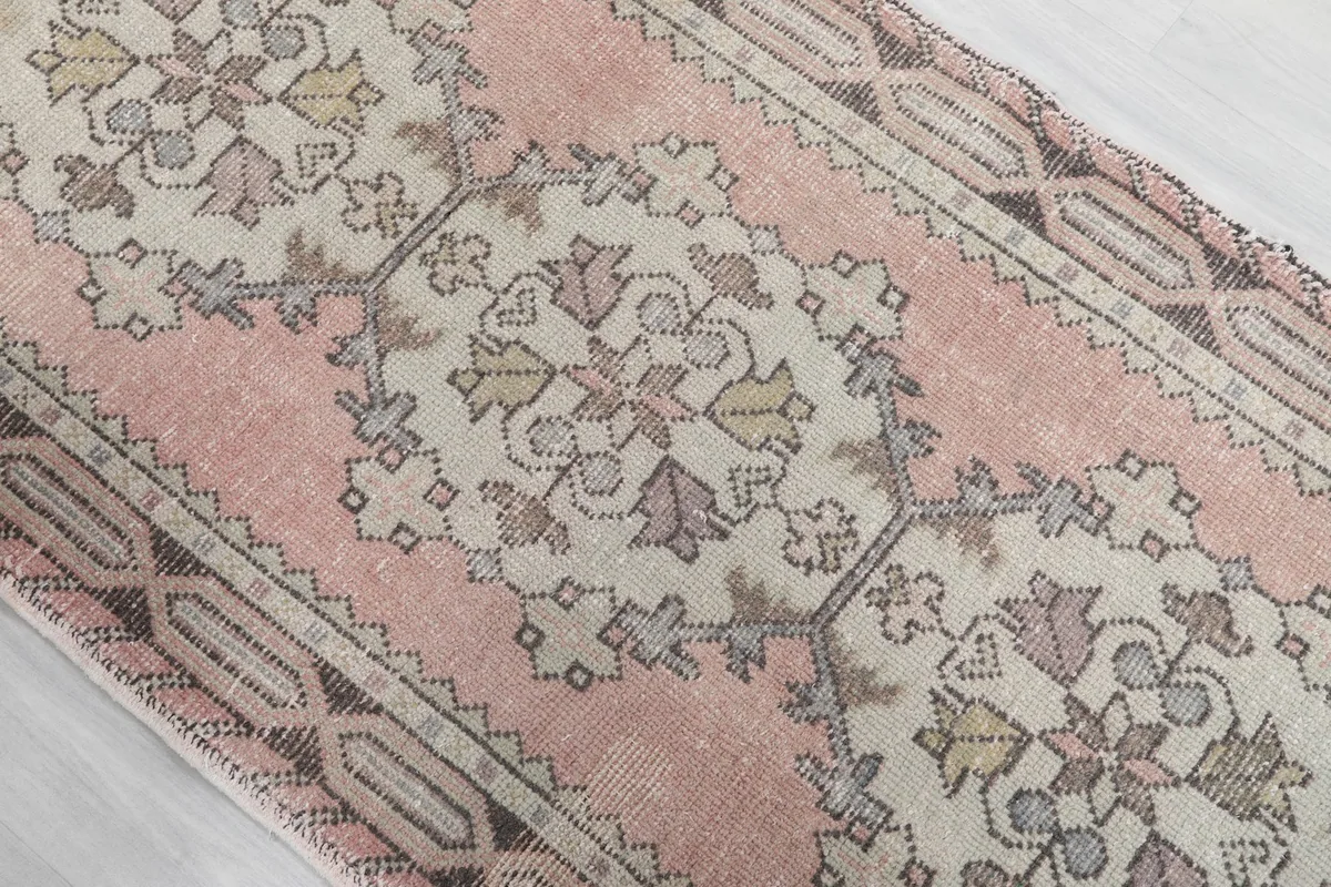 Close-up of the central ivory medallion with subtle yellow and olive accents on the rose field