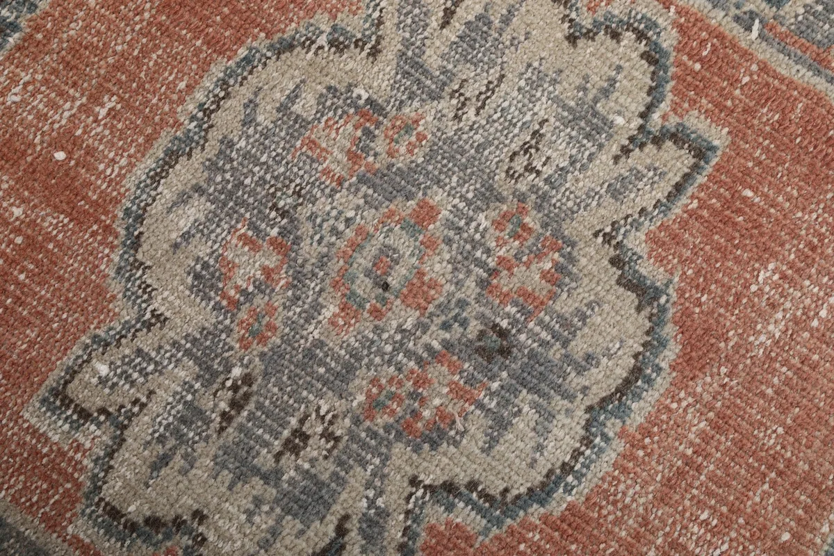 Close-up of the intricate weaving and colors within a gray medallion motif.