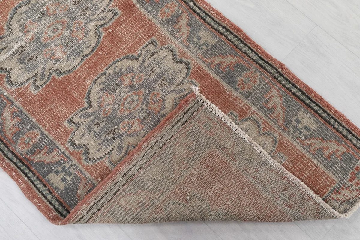 Folded corner of the rug revealing the hand-knotted wool pile and cotton foundation.