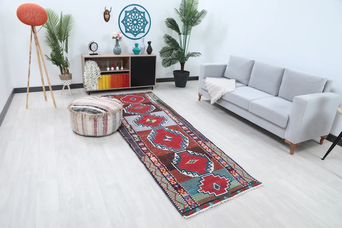 Anatolian runner rug from an elevated angle in a room, highlighting its placement next to a sofa and ottoman.