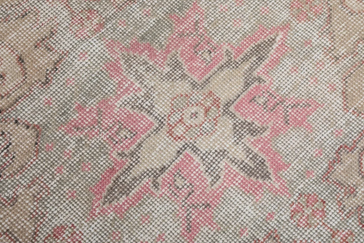 Close-up of the central medallion design, revealing the intricate patterns and low pile