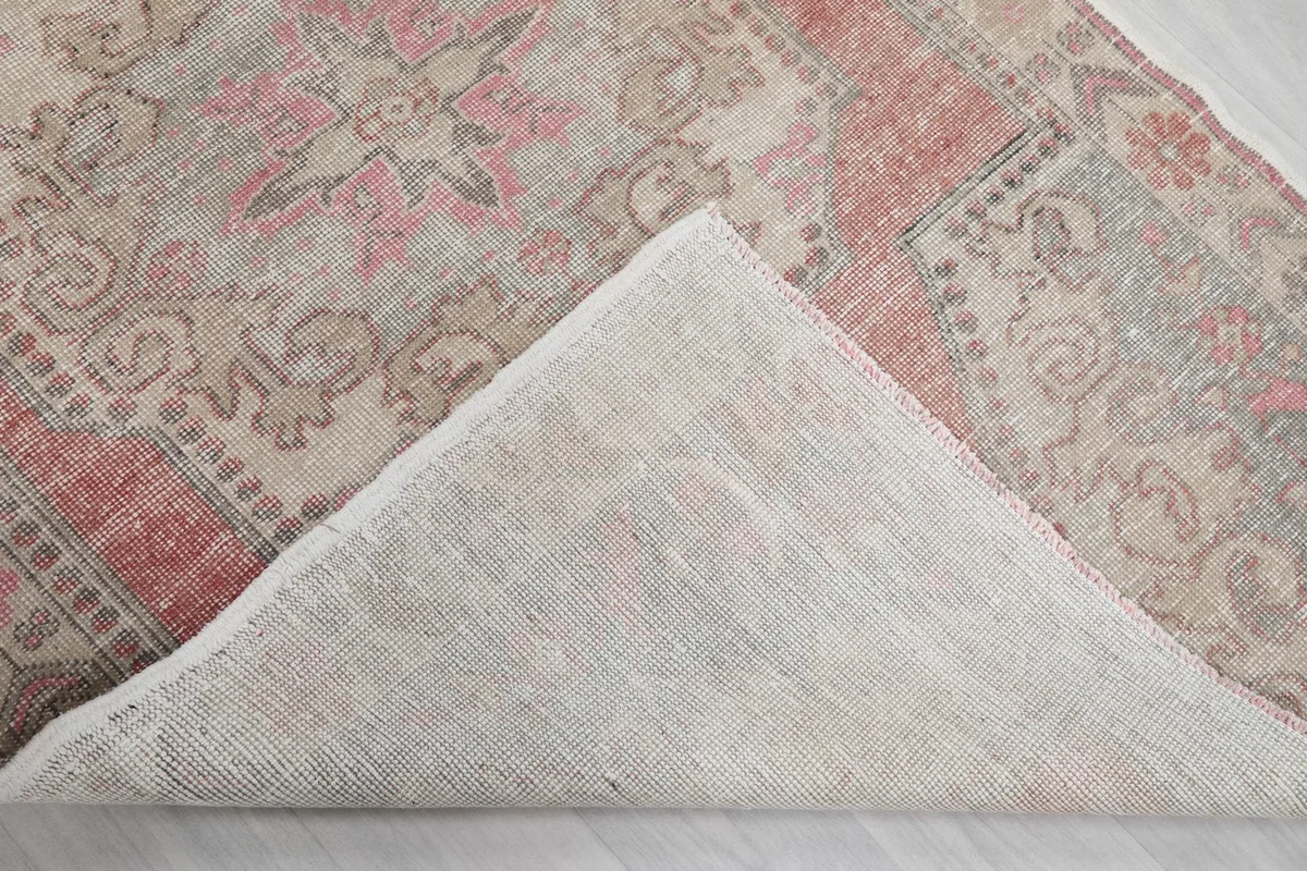 View of the back of the rug, showing the cotton foundation and hand-knotted construction