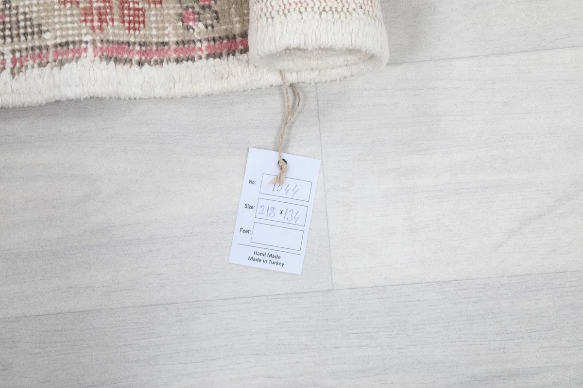 Rug tag displaying origin and material details, next to the rolled edge of the rug