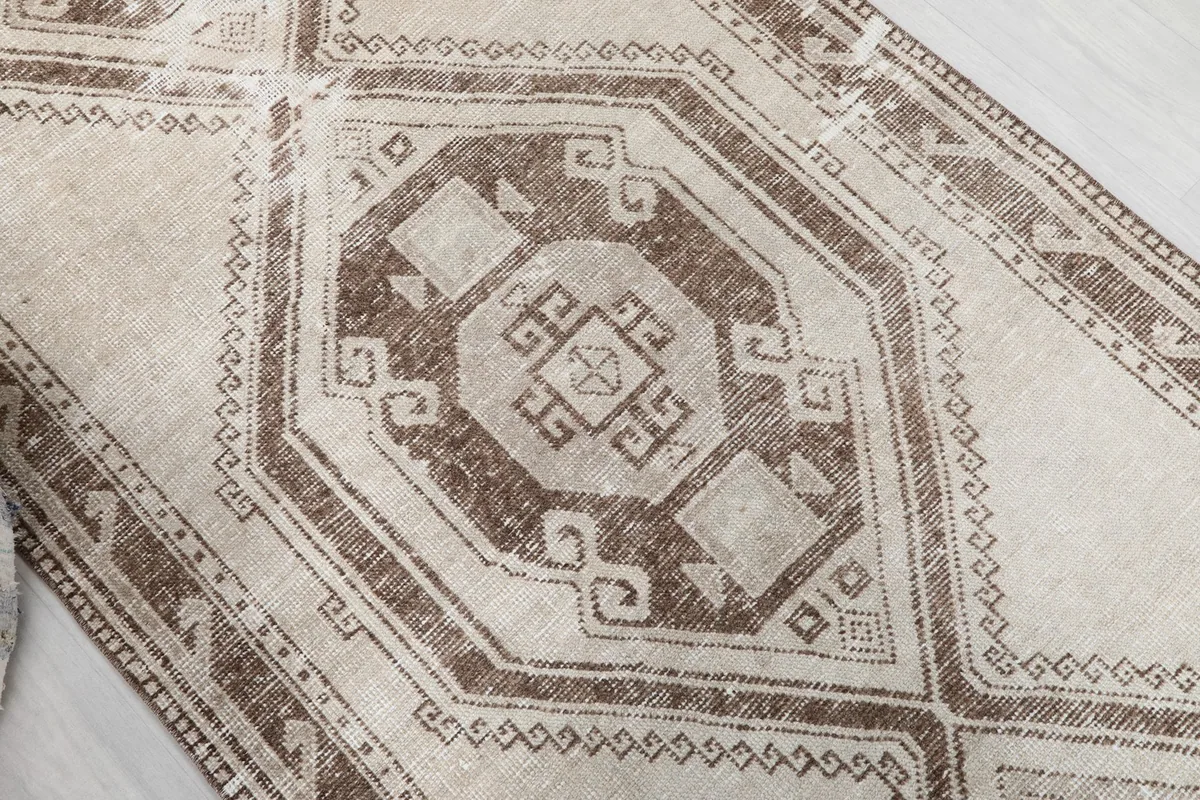 Overhead close-up of a central geometric medallion with intricate tribal motifs.