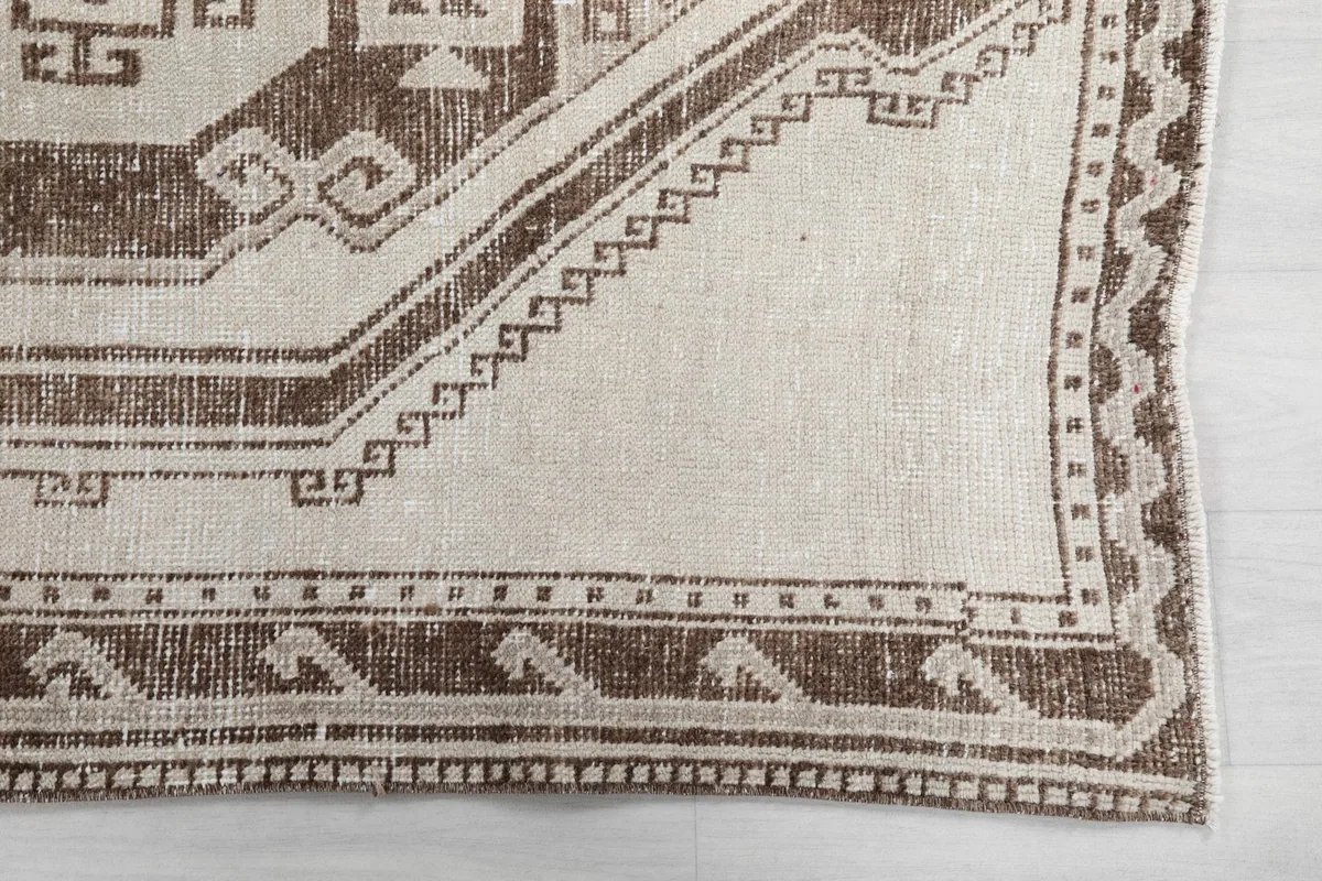 Detail of the rug's border design and corner, showcasing the hand-knotted wool texture.