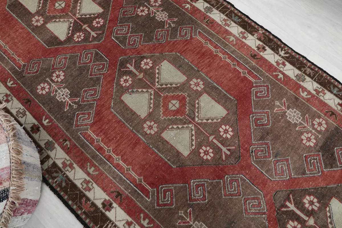 Overhead angle shot focusing on the central geometric medallions and floral accents of the rug