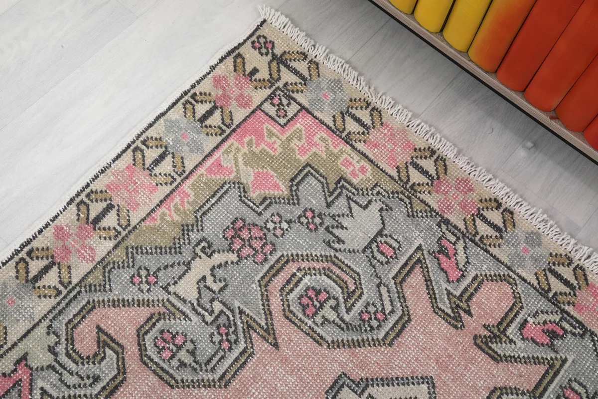 Detail of the rug's top left corner, showing border and field patterns.