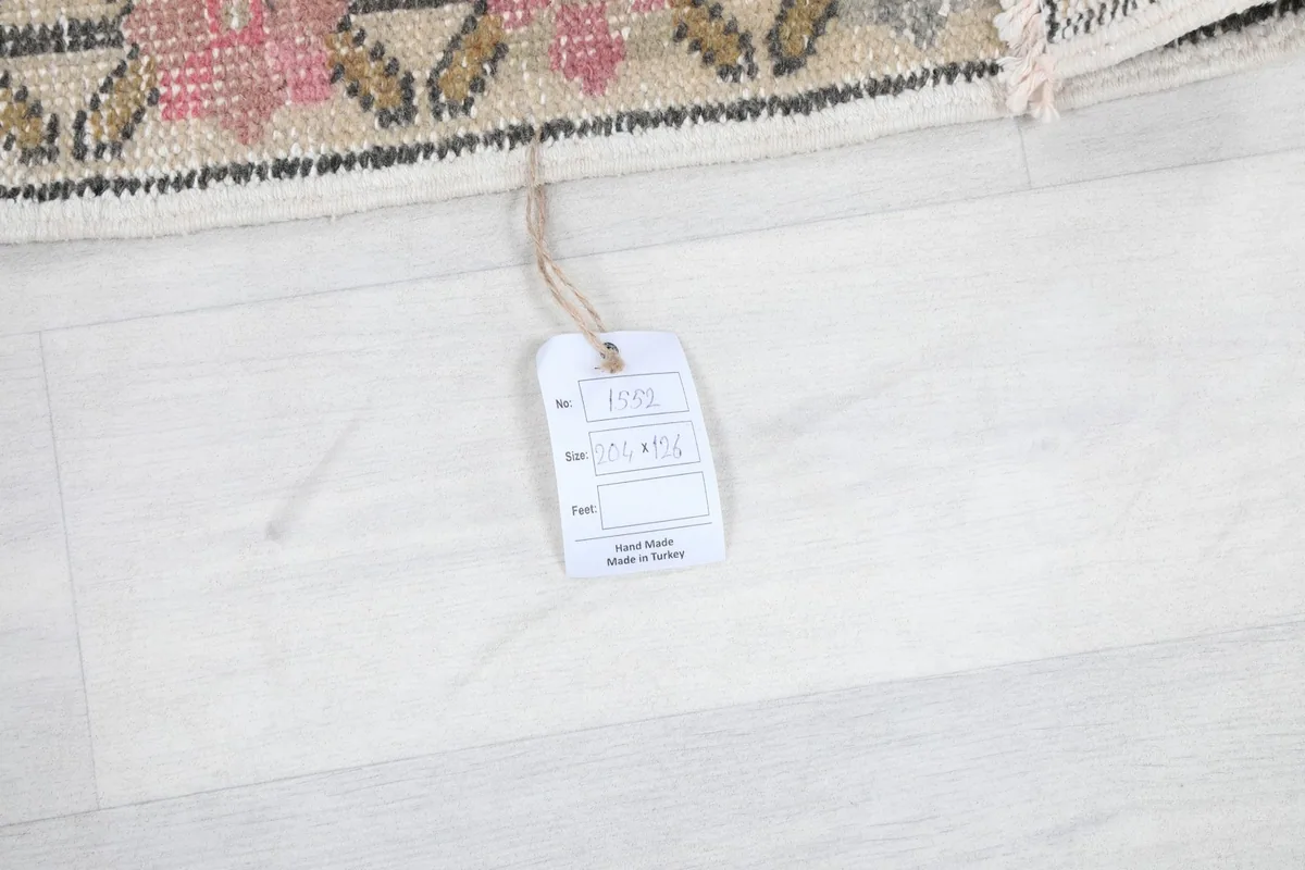 Product tag on the rug, indicating it is hand-knotted wool from Turkey.