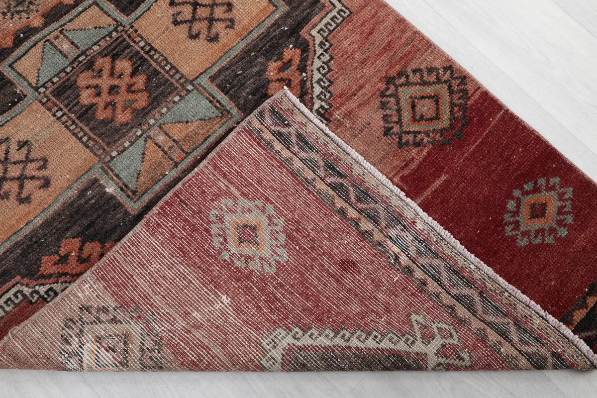 Corner of the rug folded to show the hand-knotted cotton foundation and wool pile