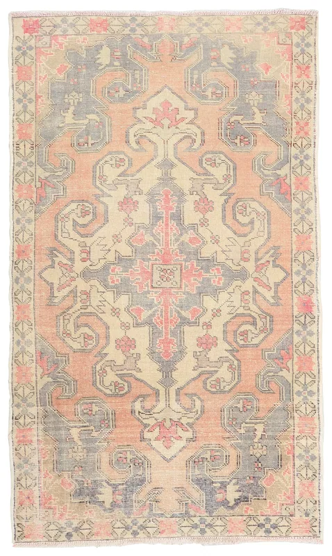 Full overhead view of the vintage Anatolian rug with rose, orange, and gray medallion on an ivory field