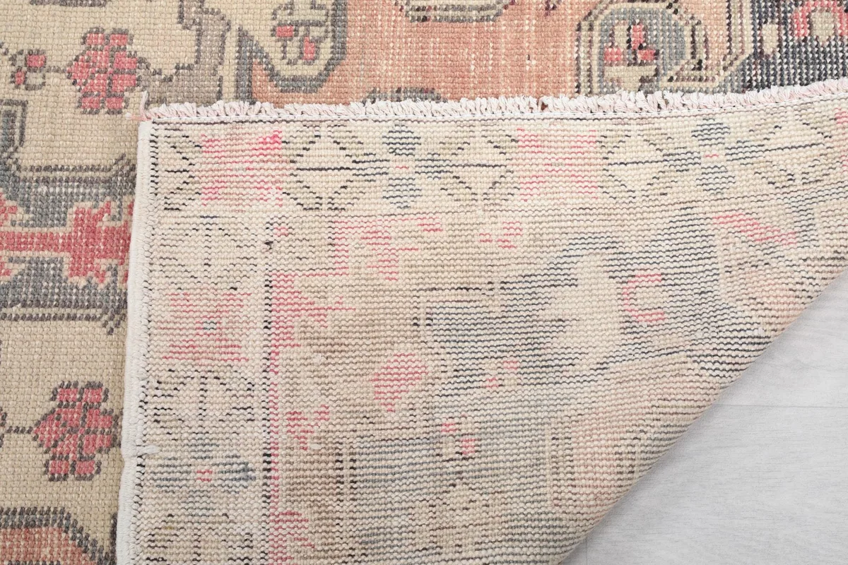 Folded corner of the rug, revealing the back and the texture of the wool pile