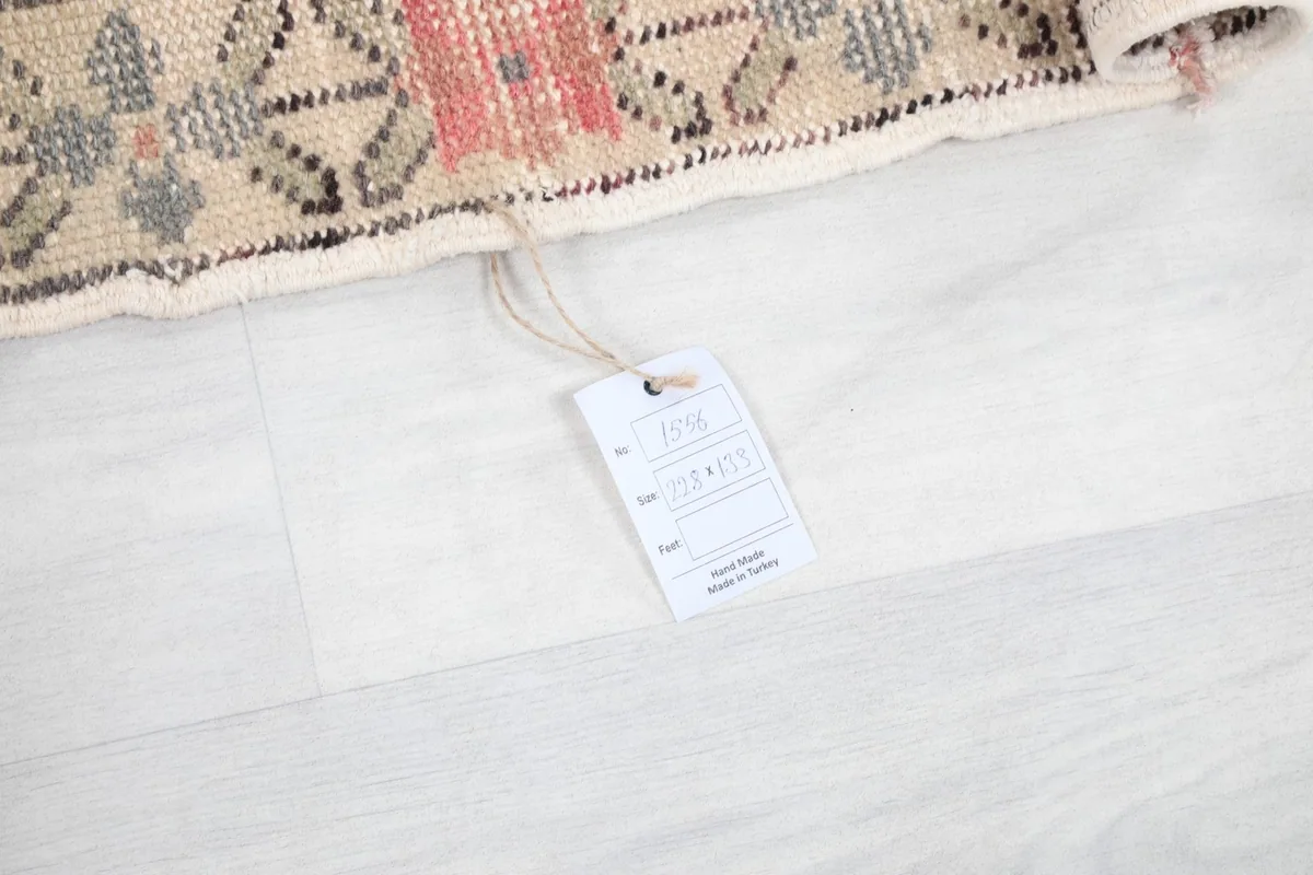 Product tag attached to the rug, indicating its hand-knotted origin and material