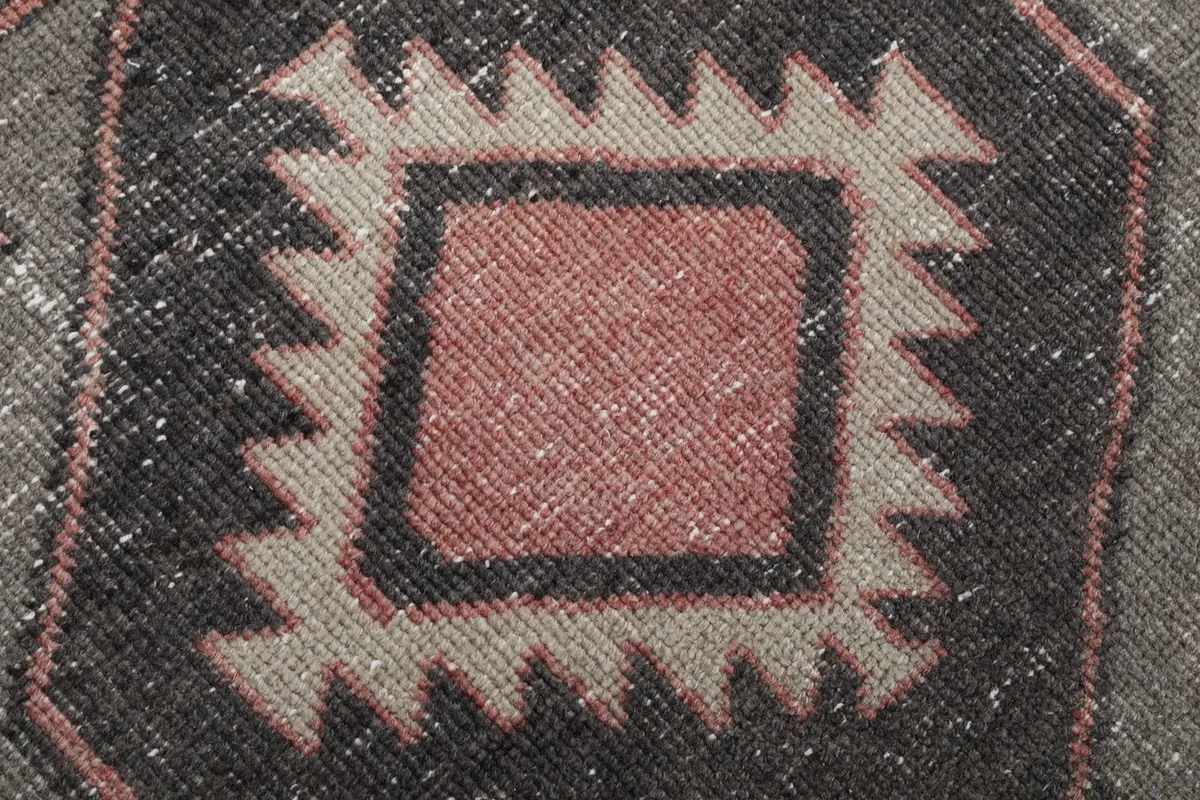 Extreme close-up of the rug's pile, revealing the texture and subtle color variations within the patterns.