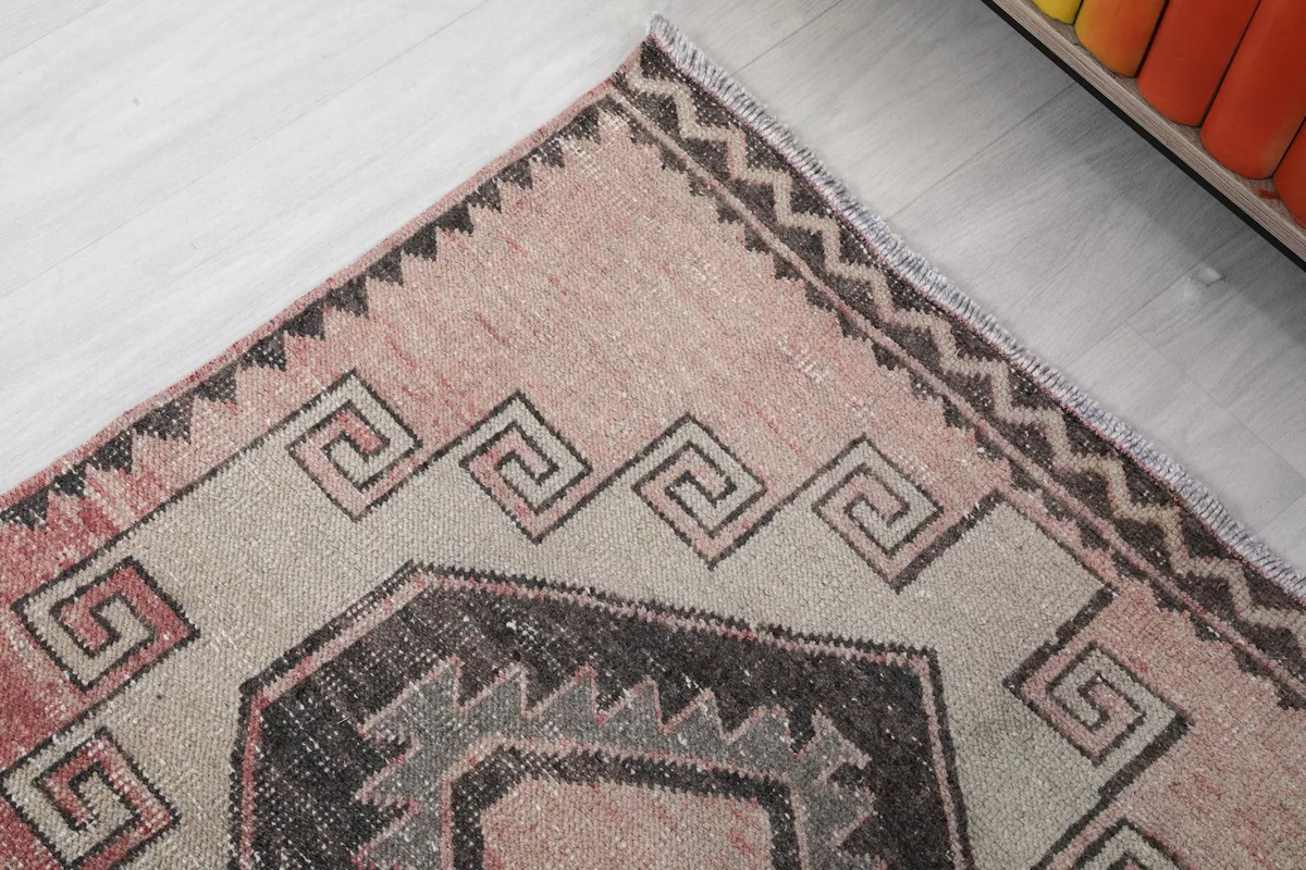 Close-up of the rug's end border and fringe, showing the intricate geometric border design.
