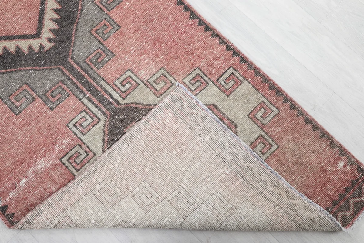 Corner of the rug folded back to reveal the cotton foundation and hand-knotted construction.